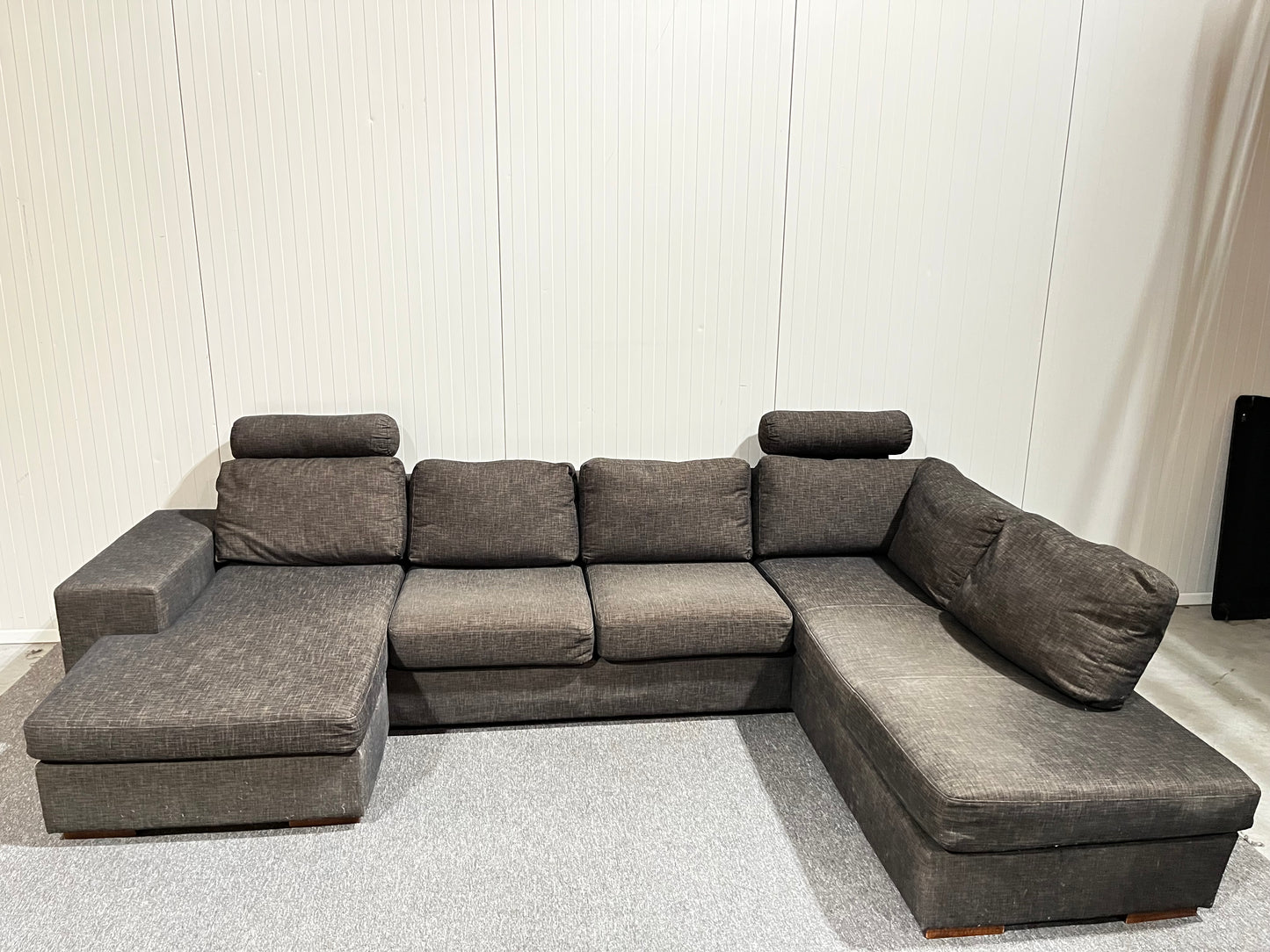 Grå stor U-soffa med två nackstöd