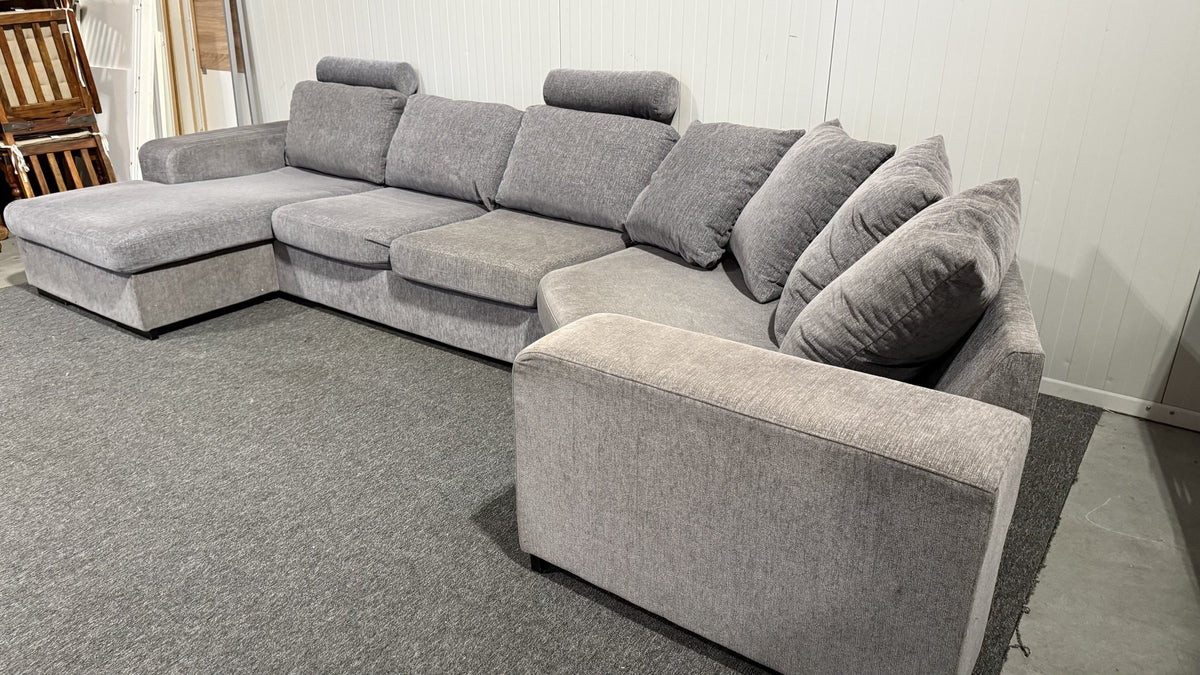 Fällbara nackstöd på grå U-soffa