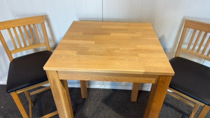 Begagnat träfärgat IKEA barbord med läderstolar
