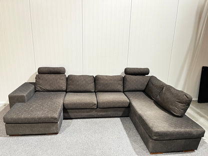 Grå stor U-soffa med två nackstöd