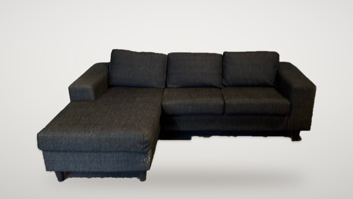 Begagnad svart soffa med divan snett framifrån