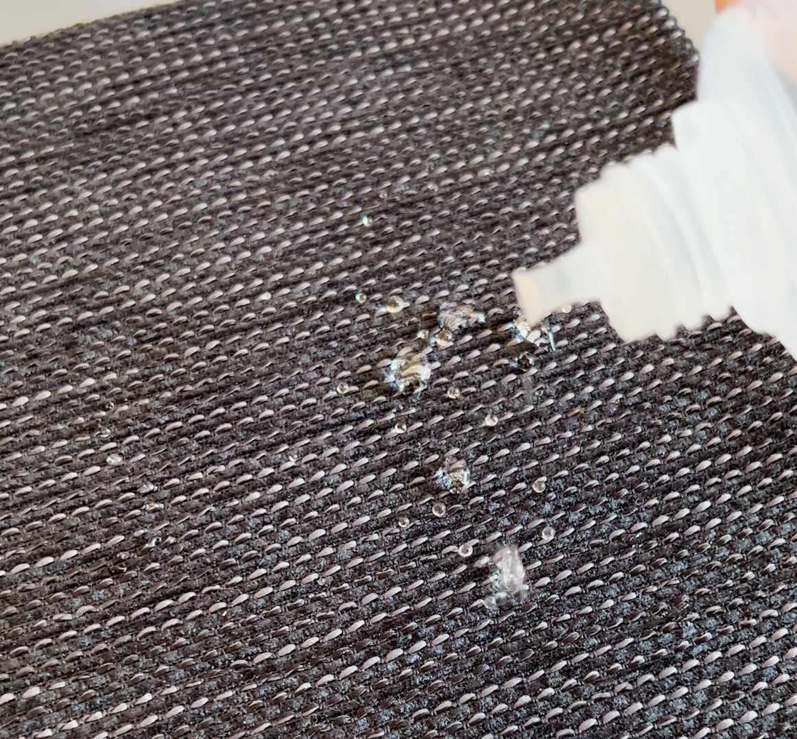 Vattendroppar på tyg som visar skyddande effekt av Textile Protection impregnering