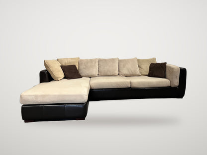 Begagnad stor soffa med schäslong i svart läder och beige klädsel framifrån