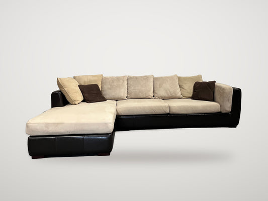 Begagnad stor soffa med schäslong i svart läder och beige klädsel framifrån