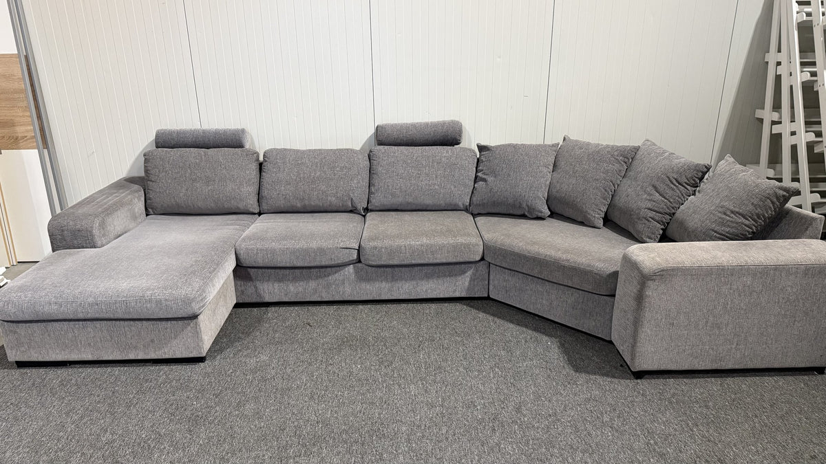Detalj av nackstöd och tyg på grå U-soffa