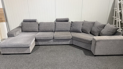 Detalj av nackstöd och tyg på grå U-soffa