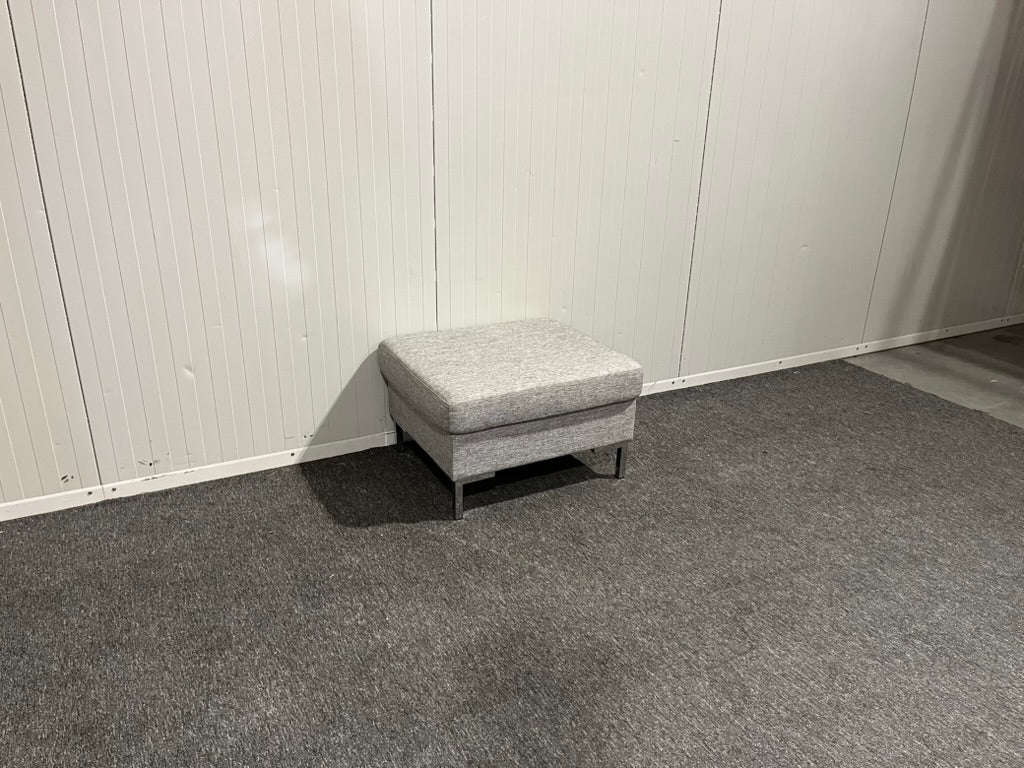 Begagnad grå fotpall framifrån