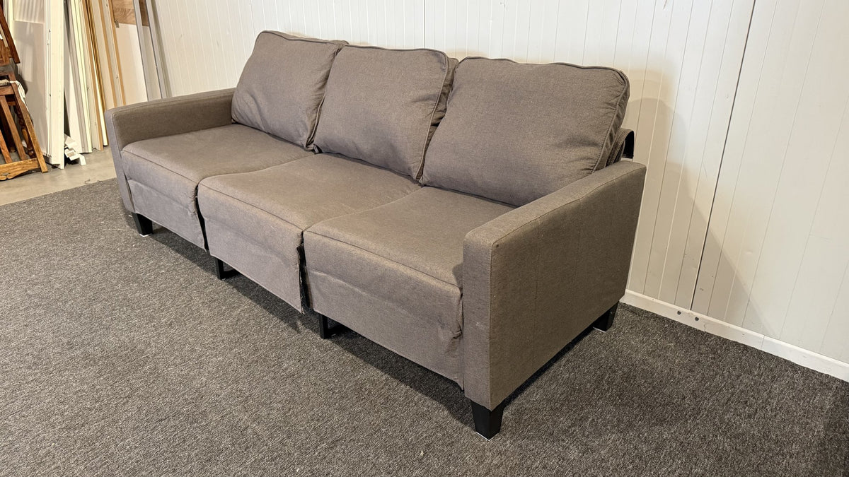 Närbild på tyg och sittdynor på grå tresitssoffa