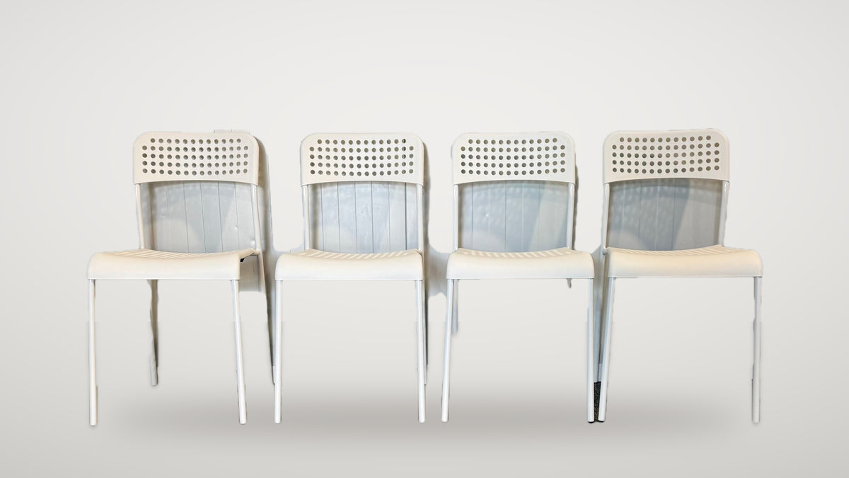 Fyra begagnade vita IKEA stolar framifrån